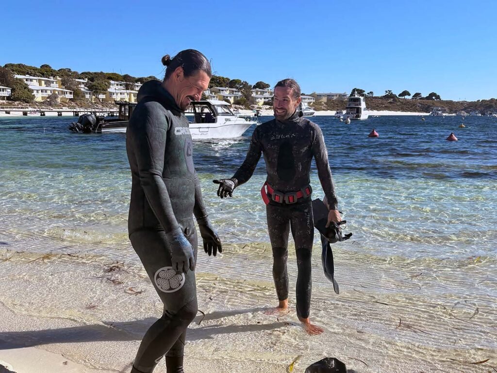 Two cray fishermen on Rottnest Island with Geordie Bay in background