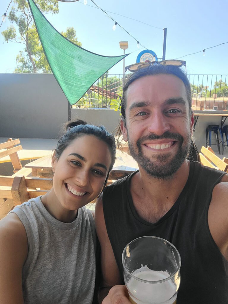 Smiling couple with pint of beer at pub in Tom Price after Hiking Mount Bruce in Karijini.