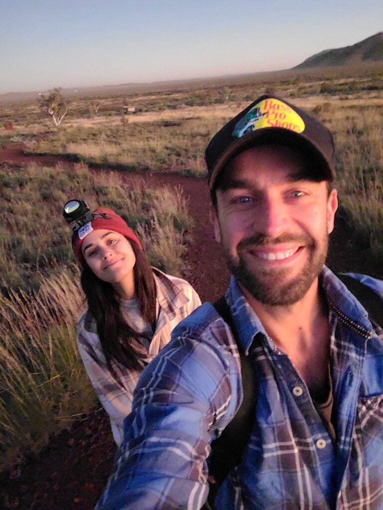 Two hikers with head torch on and trail behind for Mount Bruce in Karijini National Park.