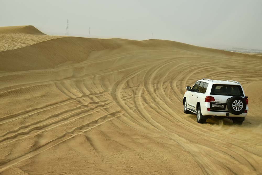 4WD driving up a steep sand dune in Australia