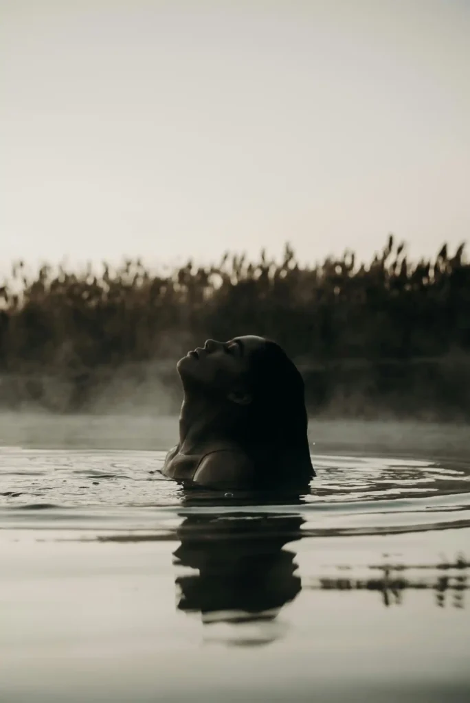 Close up of woman in hot spring in Western Australia with steam rising above her head