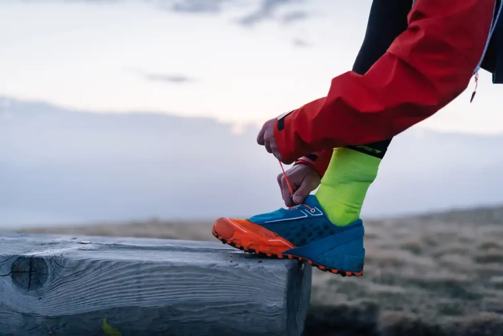 Trail runner tying up trail running shoelaces outdoors