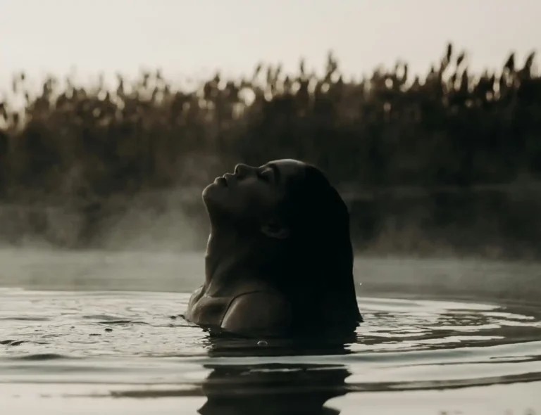 Close up of woman in hot spring in Western Australia with steam rising above her head