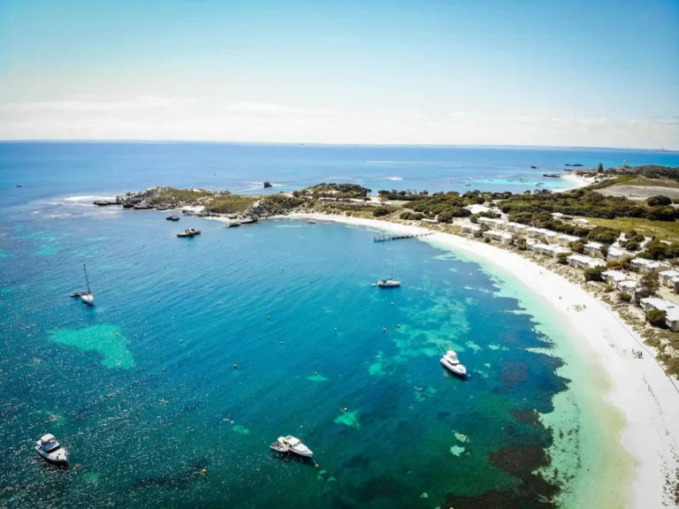 Drone shot of Rottnest Island bay, boats in the turquoise waters and Indian Ocean in background